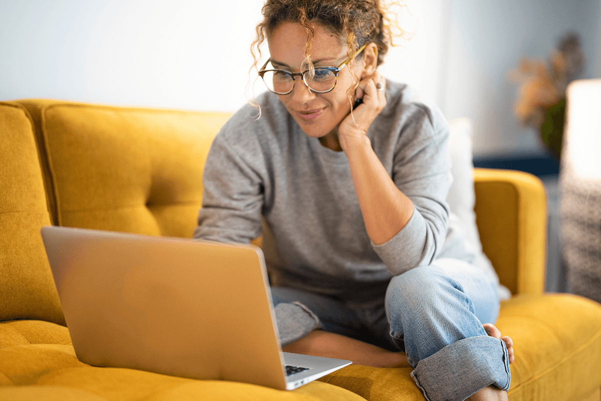 woman lounging on the couch with her laptop open