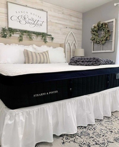 Stearns and Foster mattress on a tan bed frame with skirt and patterned rug.jpg