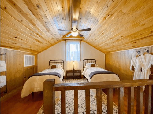 two twin beds inside log cabin bedroom